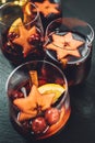 Table close-up still-life with Mulled wine with spices, fruits, cinnamon served in thin glasses. Hot beverages during cold season Royalty Free Stock Photo
