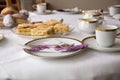 Table with coffe or tea cups, cake, plates