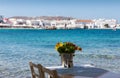 Table and flowers in front of the town of Mykonos Royalty Free Stock Photo