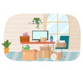 Table with computer in apartment, home office. Modern workplace interior with boxes and houseplant. Royalty Free Stock Photo