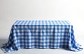 Table covered with blue, white gingham tablecloth. Fabric textile features classic checkered pattern. Clean empty surface ready Royalty Free Stock Photo