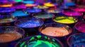 A table covered in bowls of neon paint ready for guests to create their own glowing masterpieces on canvas