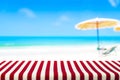 Table covered with striped tablecloth on blurred beach background