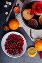 On the table is cranberries, a pan with a mulled wine, an orange and a lemon. View from above. Royalty Free Stock Photo
