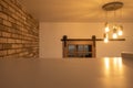 Table, creative concrete lamp, brick wall and wooden sliding door.