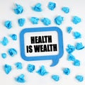 On the table are crumpled blue pieces of paper and a thought plate with the inscription - Health Is Wealth Royalty Free Stock Photo