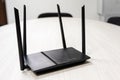On the table is a dark Wi-Fi router to access the Internet