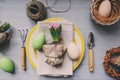 Table decorated for Easter with wrapped hyacinth flower, garden tools and colorful plate. Cozy home setting