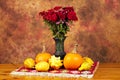 Table decorated with red rug, autumn flowers, pumpkins and squashes Royalty Free Stock Photo