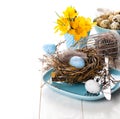 Table decoration with easter eggs nest on plate Royalty Free Stock Photo