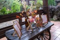 Table with decorative wheels, lined with bottles with leaves and reeds, plates in frames, glasses with lollipops