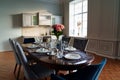 table with dishes and bouquet of roses in the bright kitchen of the living room