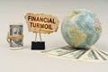 On the table are dollars, a globe and there is a sign with the inscription - financial turmoil