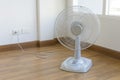 Table electric fan sit on the wooden floor Royalty Free Stock Photo