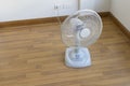 Table electric fan sit on the wooden floor Royalty Free Stock Photo