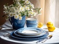 table with elegant vase with flowers and ceramic plates in white-blue colors Royalty Free Stock Photo