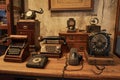 A table is filled with a collection of antique telephones and various other vintage items, Virtual assistant devices from Royalty Free Stock Photo