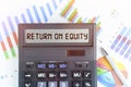 On the table are financial charts and a calculator, on the electronic board of which is written the text - RETURN ON EQUITY