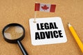 On the table is the flag of Canada, a pencil, a magnifying glass and a sheet of paper with the inscription -Legal Advice