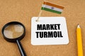 On the table is the flag of India, a pencil and a sheet of paper with the inscription - market turmoil