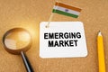 On the table is the flag of India and a sheet of paper with the inscription - emerging market Royalty Free Stock Photo