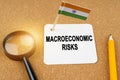 On the table is the flag of India and a sheet of paper with the inscription - macroeconomic risks