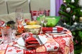 Table with food in a domestic kitchen, laid and decorated for New Year celebration. Christmas tree