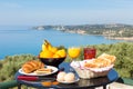 Table with food and drinks in front of blue sea and beach Royalty Free Stock Photo