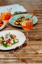 Table with food and drinks on the restaurant terrace on a summer day. Aperol spritz in a summer. Royalty Free Stock Photo