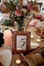 Table with food, flowers, candles and table number. Royalty Free Stock Photo