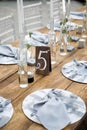 Table with food and flowers on the wedding. Number 5 written on white card stands before the bouquet in the center of dinner table Royalty Free Stock Photo