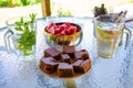 Table full of food, fresh drinks, bowl full of watermelon, sweet cake.