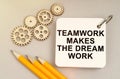 On the table are gears, pencils and a notebook with the inscription - Teamwork Makes the Dream Work Royalty Free Stock Photo