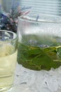 On the table In a glass mug and a teapot Fresh, floral, herbal tea made from mint and currant leaves in a mug