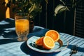 a table with a glass of orange juice and a plate of orange slices