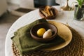 Table with a green napkin and a yellow bowl with easter eggs on it Royalty Free Stock Photo