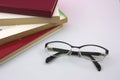 On a table we have some books and glasses to read up close