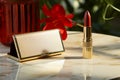 A table hosts red lipstick and a box, blending style