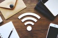 Table items brown envelope, Wi Fi symbol, smartphone, notebook, and pencil