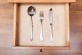 Table knife, fork, spoon in open drawer Royalty Free Stock Photo