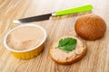 Knife, jar with liver pate, bun, sandwich with meat pate on wooden table Royalty Free Stock Photo