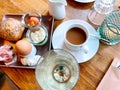 Table laid for breakfast outside in summer with various jams, bread, coffee, croissants, eggs, bacon muesli and orange juice Royalty Free Stock Photo