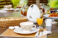 Table laid for breakfast outside with various jams coffee, crois