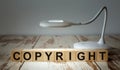 A table lamp illuminates wooden blocks with the word COPYRIGHT Royalty Free Stock Photo