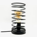 A table lamp in the shape of a shock absorber with a light bulb inside, cut out on white background Royalty Free Stock Photo
