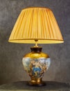 Table lamp with a yellow lampshade. The lampshade of the lamp shines with golden light