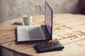 table with laptop, glasses, wallet and cup of coffee