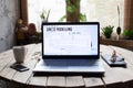 Table with laptop, glasses, wallet and cup of coffee