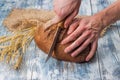 Cutting rye bread on the table with an old knife.