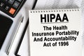 On the table lies a smartphone, a calculator and a notebook with the inscription- HIPAA Royalty Free Stock Photo